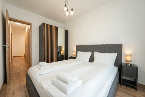 Bright modern twin bedroom with warm lighting and sleek mirrored wardrobe