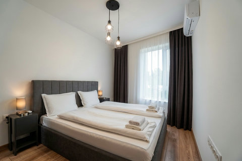 Bright modern bedroom with king bed, blackout curtains, and A/C