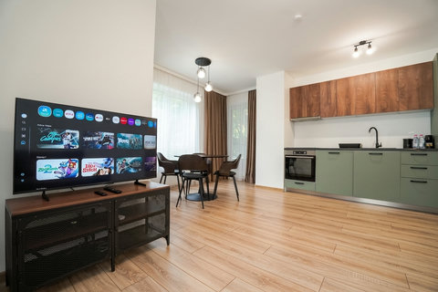 Bright modern studio with sleek kitchenette, dining area, and Smart TV