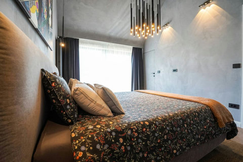 Luxury bedding with designer cushions and statement pendant lighting