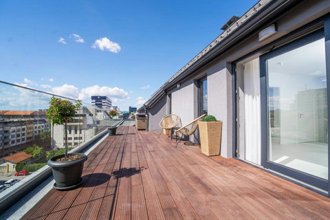 Expansive rooftop terrace with glass balustrade and 360° Sofia views