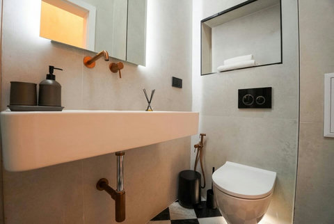 Marble-effect bathroom with floating vanity and copper rose gold accents