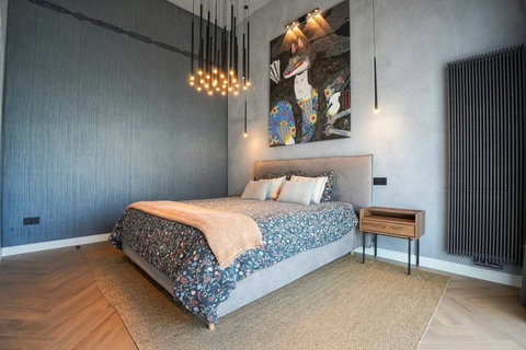 Bedroom with statement peacock artwork and designer pendant lights