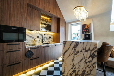 Fully equipped designer kitchen with marble-effect countertops and chandelier