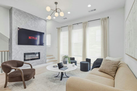 Welcome to our home, featuring seating for 12 and an open‑concept living area that overlooks the dining table and kitchen. A large arched floor mirror adds elegance and enhances the natural light throughout the space.