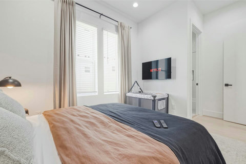 Relax in this cozy bedroom featuring a sleek wall‑mounted TV, a closet and your own private bathroom, perfect for comfort, privacy, and unwinding after a long day.