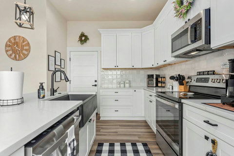 Bright chef-ready kitchen with farmhouse sink, quartz tops and coffee bar.