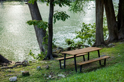 Shaded waterfront picnic table—relax under trees with peaceful views.