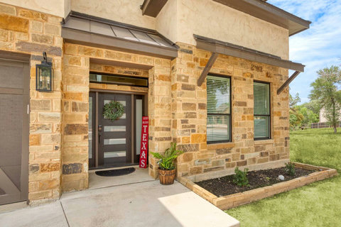 Inviting stone facade with sleek modern door and covered porch entry