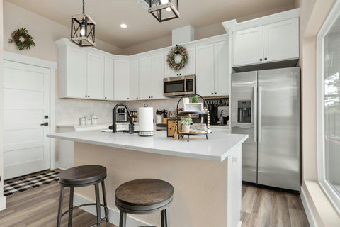 Bright chef’s kitchen with coffee bar, island seating, and stainless steel