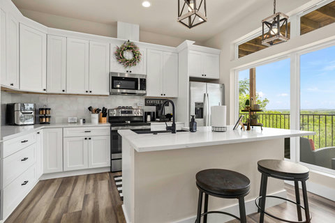 Bright chef’s kitchen with coffee bar, island seating & view deck