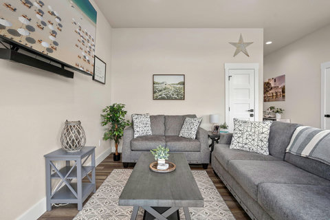 Bright lounge with comfy sofas, wall-mounted TV, and coastal decor