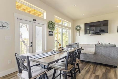 Dine in style at this chic table, flowing into a bright white kitchen with stainless steel appliances and a cozy rustic touch. Perfect for meals & mingling!
