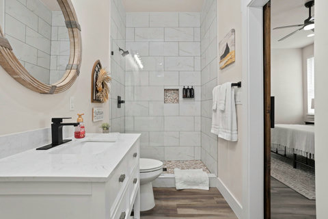 Stylish bath with walk-in shower, quartz vanity & matte black accents