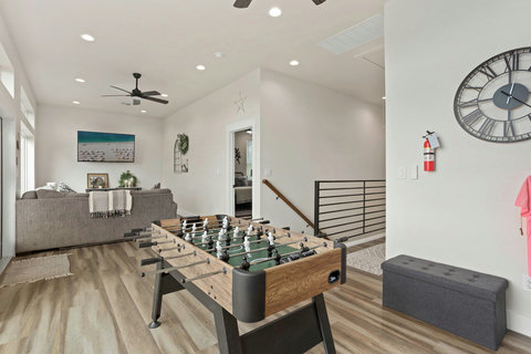 Bright game loft with foosball, comfy sectional, and modern finishes
