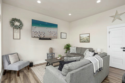 Bright lounge with big-screen TV, plush sectional, and chic decor.