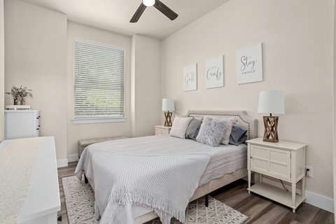 A guest bedroom with a plush bed dressed in luxurious linens. Warm lighting creates a soothing, restful atmosphere.
