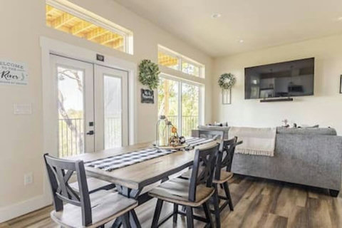 Dine in style at this chic table, flowing into a bright white kitchen with stainless steel appliances and a cozy rustic touch. Perfect for meals & mingling!