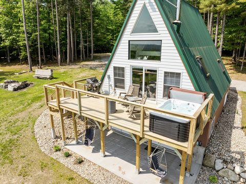 Hot tub and deck. Swinging chairs on the lower level and picnic table. 
