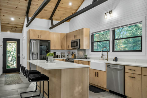 Fully appliance kitchen with white countertops. Nice view of the water and nature. 