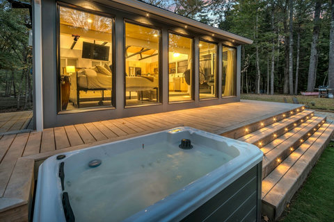 Designer Tiny Home with built in lights on the deck next to 2 fire pits. 
