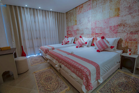 Triple room with red patterned wall / Chambre triple avec mur à motifs rouges