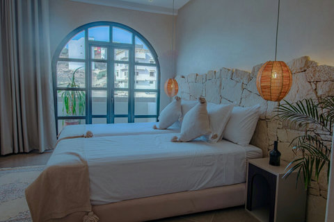 Bed, woven lamp and arched window / Lit, lampe tressée et fenêtre en arc