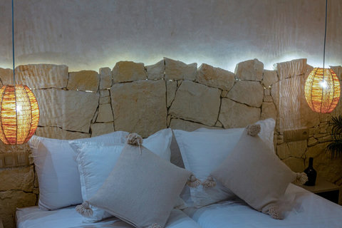Pillows against the lit stone wall / Oreillers contre le mur en pierre éclairé