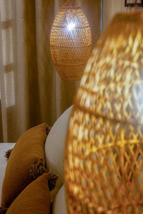 Woven pendant lamp by the bed / Suspension tressée près du lit