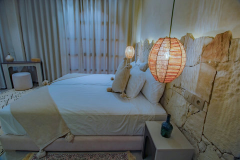 Double bed with stone wall and woven lamp / Lit double, mur en pierre et lampe tressée