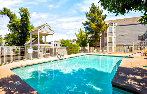 Sparkling gated pool with loungers and shaded cabana—your sunny escape.