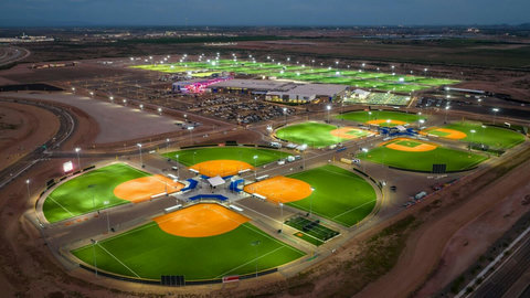 Aerial twilight view of a brightly lit sports complex nearby