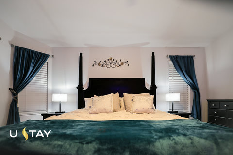 Elegant king bedroom with four-poster bed and stylish blue accents