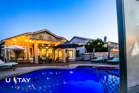 Private pool oasis with string lights, patio seating, and sunset ambiance