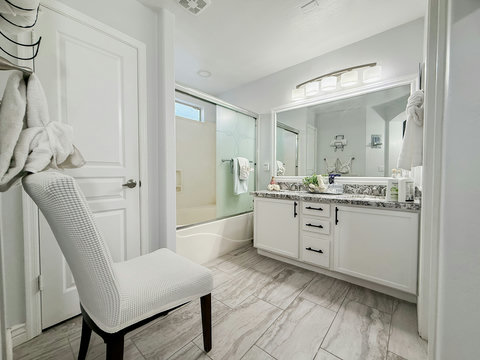 Bright modern bathroom with double vanity and tub-shower combo