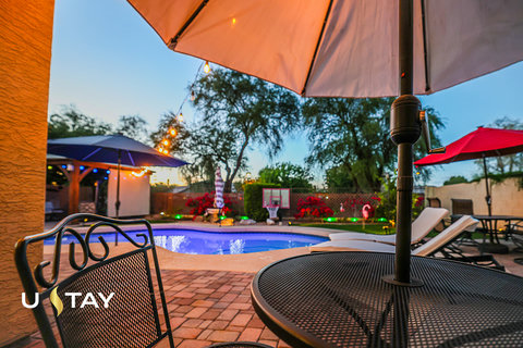 Inviting resort-style backyard with pool, lounge chairs, and evening ambiance
