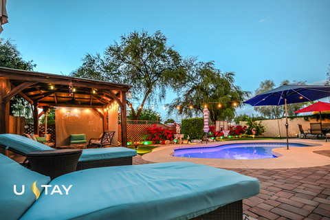 Resort-style backyard with private pool, pergola, and cozy evening lighting