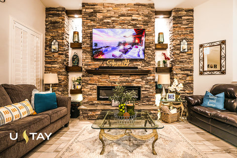 Cozy living room with stone fireplace, big TV, and stylish seating