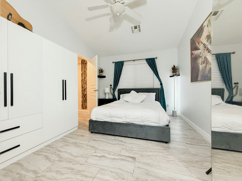 Bright modern bedroom with large wardrobes and stylish decor