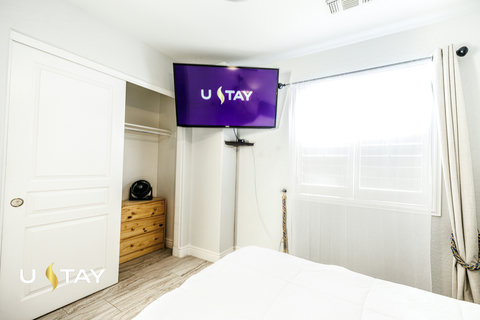 Bright bedroom with TV, natural light, and convenient closet storage