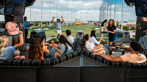 Open-air golf lounge with food, drinks, and fun group-friendly vibes