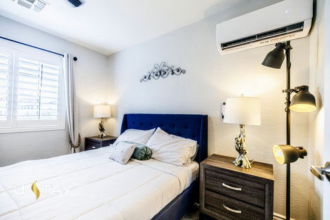 Bright, cozy bedroom with plush bed, stylish lighting, and AC comfort