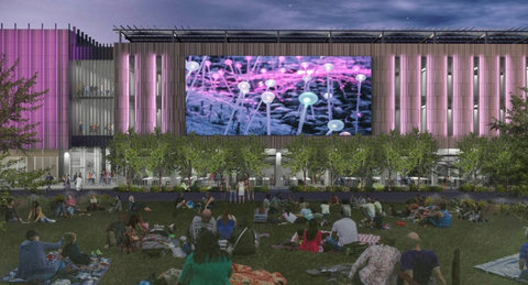 Vibrant outdoor lawn and iconic lit facade with giant event screen