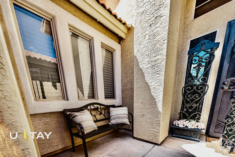 Inviting covered entry with wrought-iron details and cozy bench seating