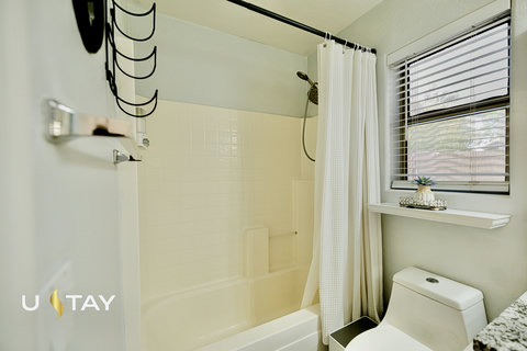 Bright full bathroom with tub-shower combo and natural light