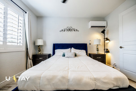 Bright, cozy bedroom with plush bed, stylish lighting, and AC