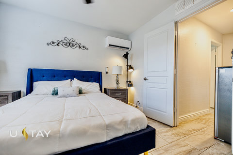 Cozy modern bedroom with plush blue bed and in-room A/C