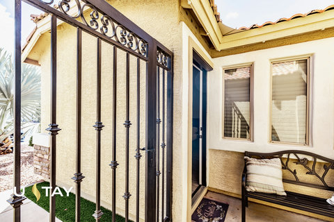 Inviting gated entry with cozy bench seating and charming curb appeal