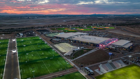 Aerial sunset view near a premier sports complex with lit fields