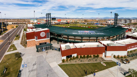 Aerial view of a modern baseball stadium with mountain vistas